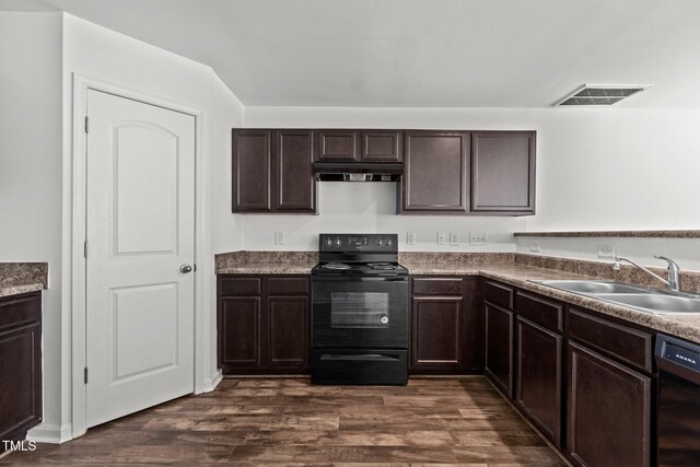 kitchen with black appliances, a sink, dark wood-type flooring, dark brown cabinets, and under cabinet range hood