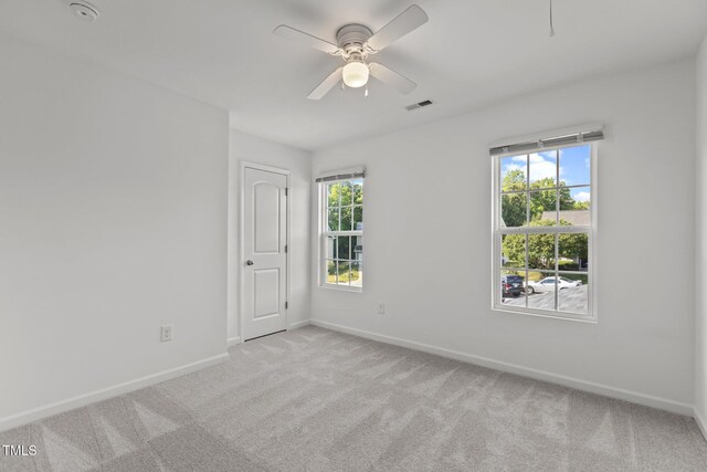 spare room with carpet floors, baseboards, ceiling fan, and plenty of natural light