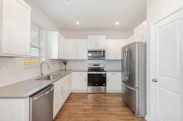 19 Cecina Ct, Clayton, NC 27527 - kitchen featuring appliances with stainless steel finishes, tasteful backsplash, white cabinets, dark wood-type flooring, and recessed lighting