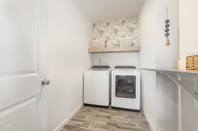 19 Cecina Ct, Clayton, NC 27527 - clothes washing area featuring washing machine and dryer, light wood finished floors, bar with sink, and baseboards