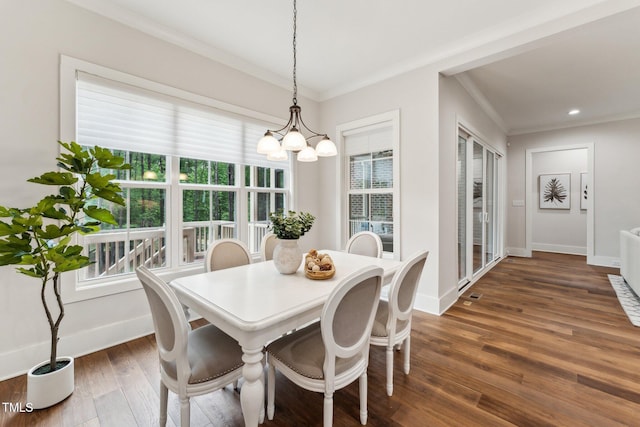 dining area with a chandelier, healthy amount of natural light, crown molding, dark wood-style flooring, and baseboards