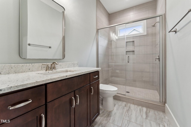 bathroom with a shower stall, toilet, and vanity