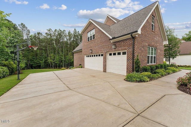 view of home's exterior with brick siding, concrete driveway, an attached garage, and roof with shingles