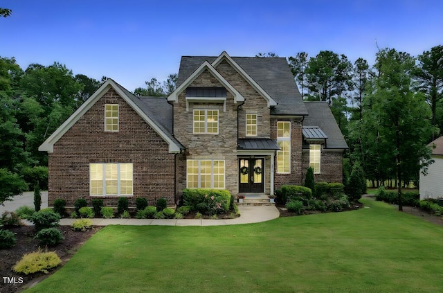 view of front facade with a front lawn, a standing seam roof, and french doors