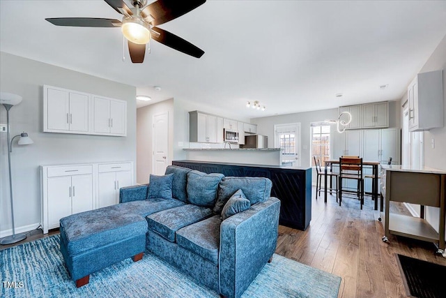 living room featuring wood finished floors and a ceiling fan