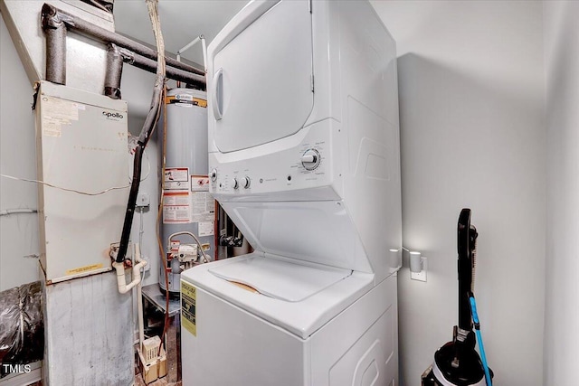 laundry room featuring stacked washer / drying machine and water heater
