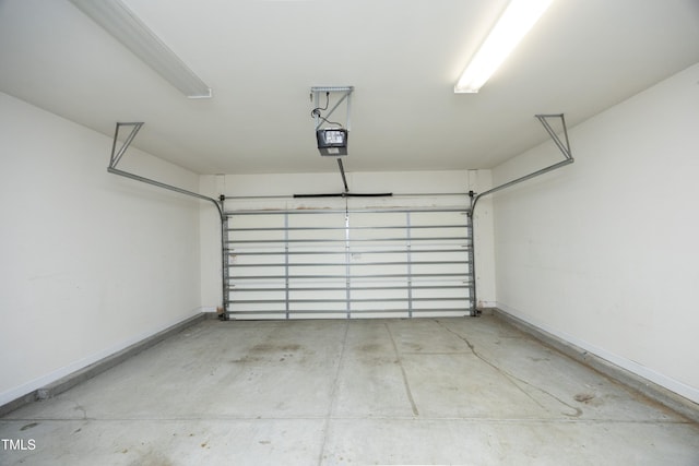 garage with a garage door opener and baseboards