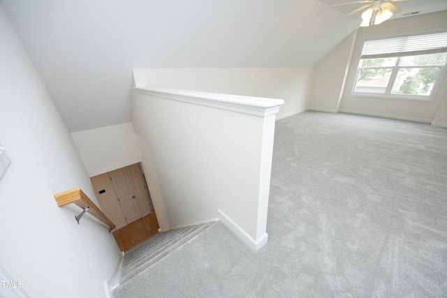 staircase featuring carpet flooring, lofted ceiling, ceiling fan, and baseboards