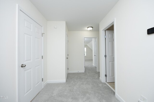 hallway with light carpet and baseboards