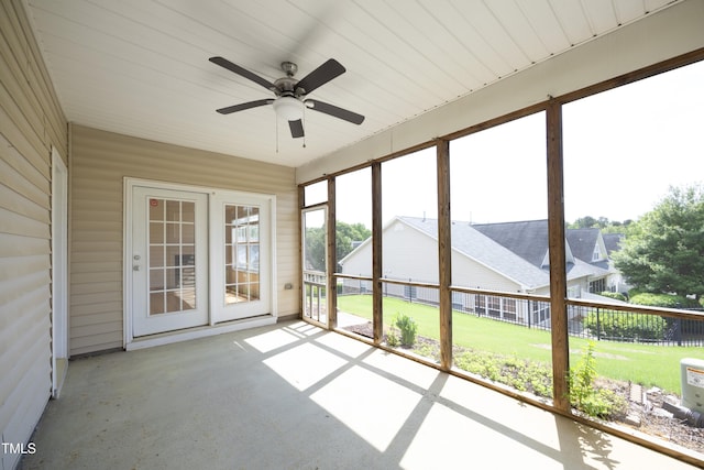 unfurnished sunroom featuring a ceiling fan