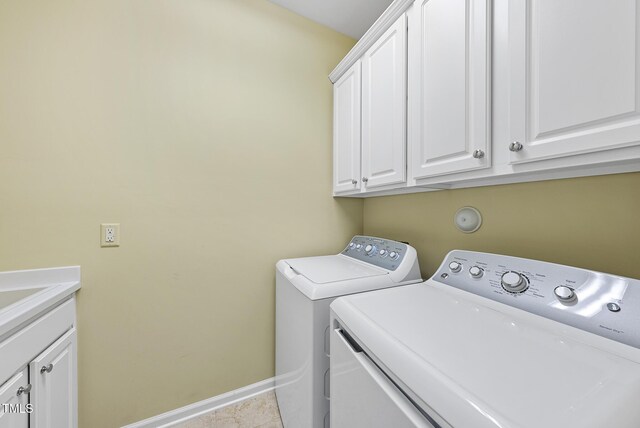 clothes washing area featuring washing machine and dryer, cabinet space, baseboards, and tile patterned flooring