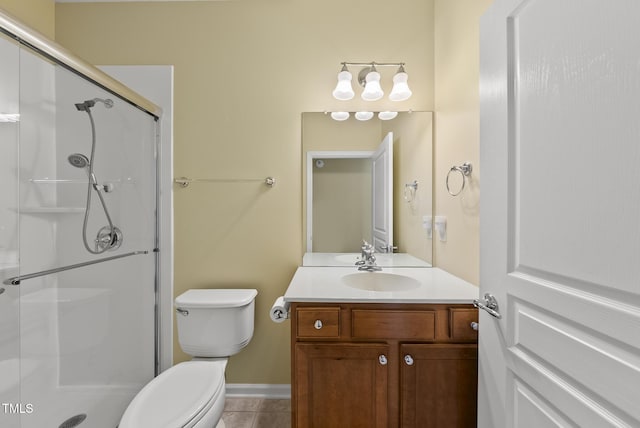full bath with a stall shower, tile patterned flooring, toilet, vanity, and baseboards