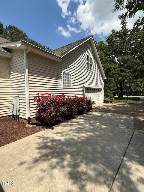 view of property exterior with a garage and concrete driveway