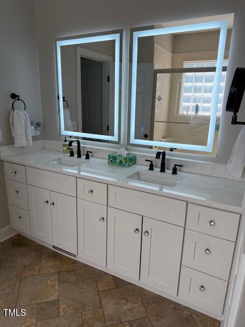 full bath featuring a stall shower and double vanity
