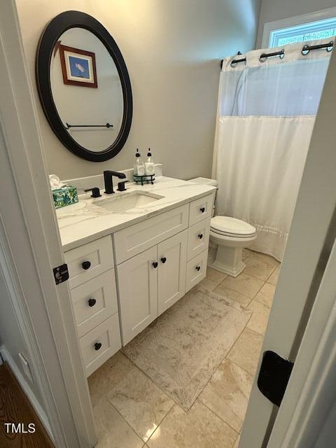 full bath with vanity, toilet, and curtained shower