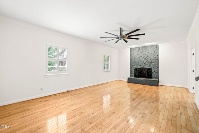 1514 Lawrence Rd, Creedmoor, NC 27522 - unfurnished living room with light wood-style flooring, crown molding, ceiling fan, a stone fireplace, and baseboards