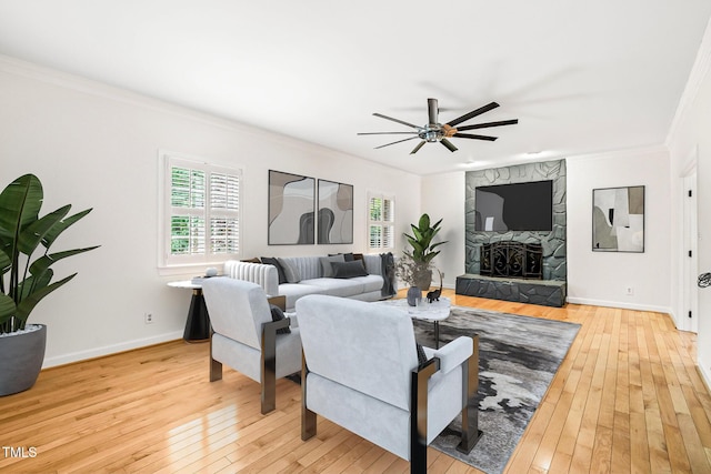 1514 Lawrence Rd, Creedmoor, NC 27522 - living area featuring crown molding, light wood-type flooring, a ceiling fan, a stone fireplace, and baseboards