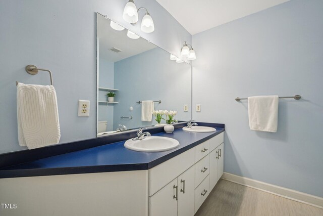 1102 Laurens Way, Knightdale, NC 27545 - bathroom featuring double vanity, wood finished floors, baseboards, and toilet