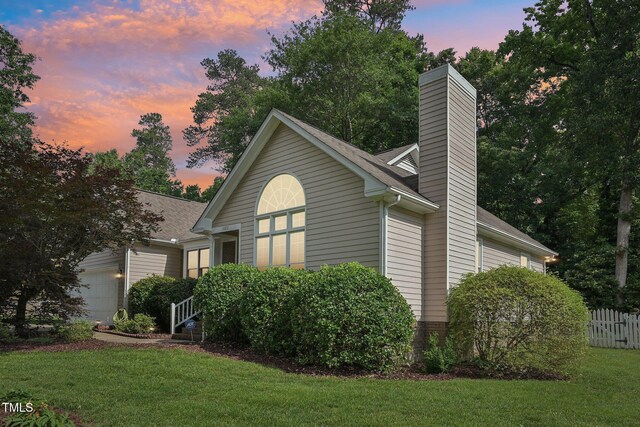 1102 Laurens Way, Knightdale, NC 27545 - property exterior at dusk with an attached garage, a chimney, and roof with shingles