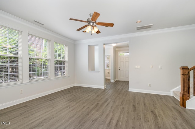 unfurnished room with ornamental molding, a ceiling fan, stairs, wood finished floors, and baseboards