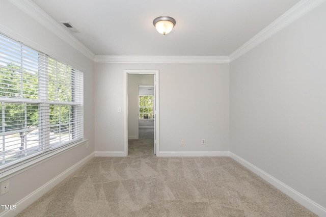 spare room featuring ornamental molding, light colored carpet, and baseboards