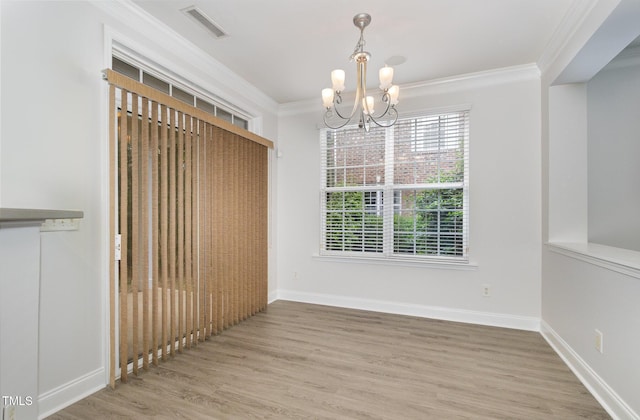 unfurnished dining area featuring a chandelier, crown molding, wood finished floors, and baseboards