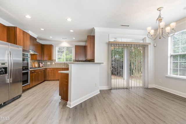 kitchen with stainless steel appliances, brown cabinetry, light wood-style flooring, crown molding, and a chandelier