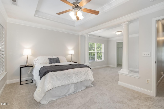 carpeted bedroom featuring ornate columns, ornamental molding, a tray ceiling, baseboards, and a ceiling fan