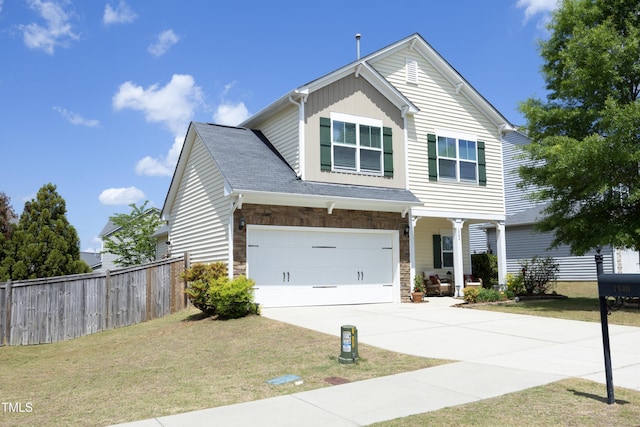 traditional-style home featuring concrete driveway, an attached garage, stone siding, and covered porch