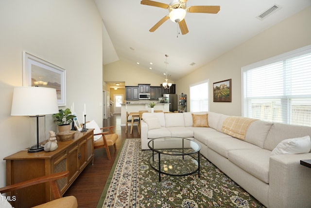 living area featuring dark wood finished floors, ceiling fan, and high vaulted ceiling