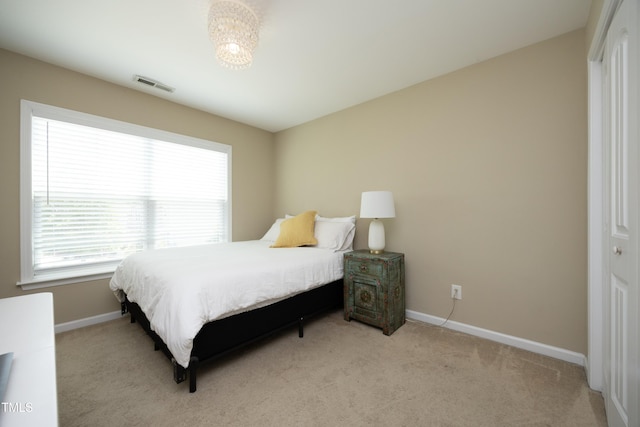 bedroom with multiple windows, baseboards, and light carpet