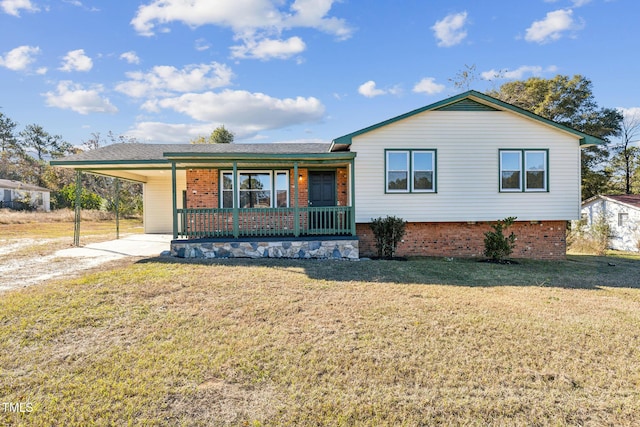 tri-level home featuring a porch, a front lawn, a carport, driveway, and brick siding