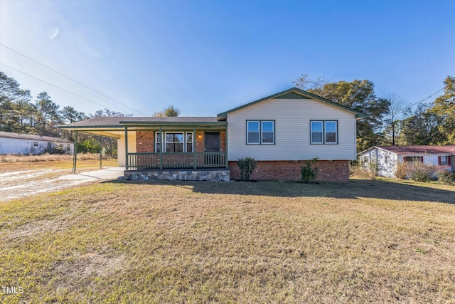 split level home featuring a porch, a front lawn, brick siding, a carport, and driveway