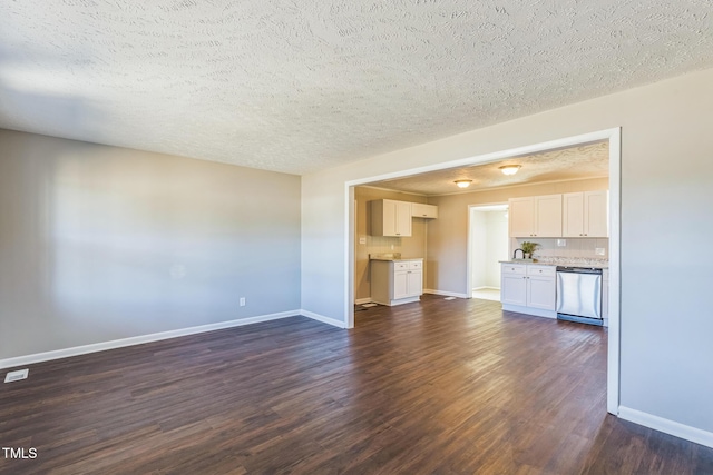 unfurnished living room featuring a textured ceiling, baseboards, and dark wood-style flooring