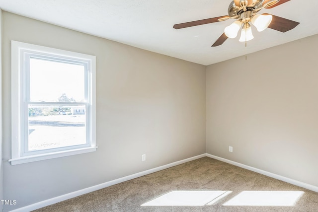 empty room featuring healthy amount of natural light, carpet, baseboards, and a ceiling fan