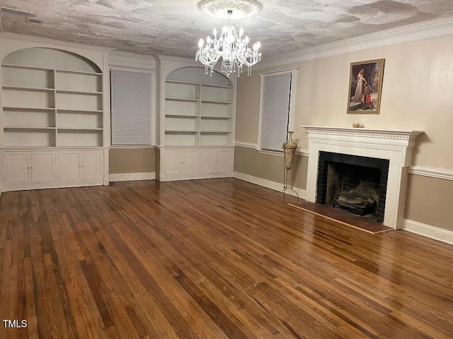 1609 Main St, Scotland Neck, NC 27874 - unfurnished living room featuring a chandelier, hardwood / wood-style flooring, a fireplace with raised hearth, built in features, and crown molding