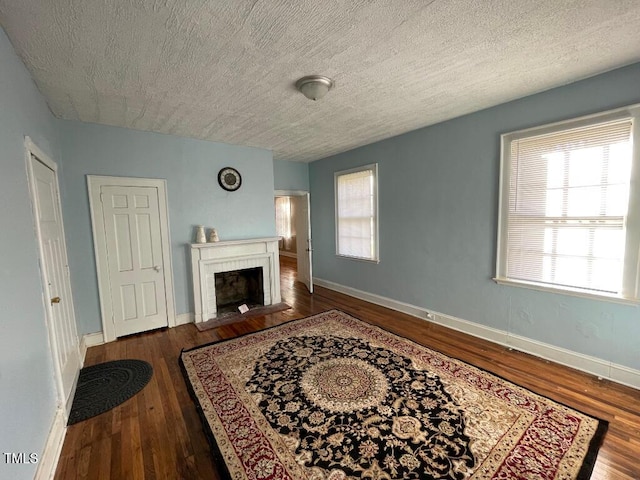 1609 Main St, Scotland Neck, NC 27874 - living room with wood finished floors, baseboards, a fireplace, and a textured ceiling