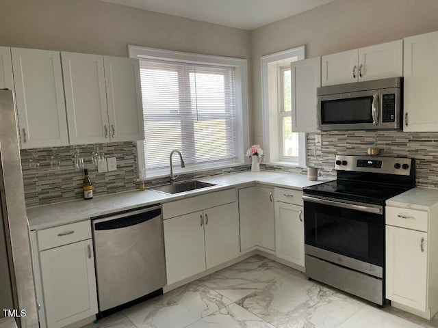 1609 Main St, Scotland Neck, NC 27874 - kitchen featuring stainless steel appliances, a sink, light marble finish flooring, and white cabinets