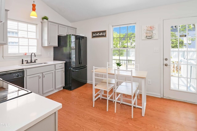 1508 Malta Ave, Raleigh, NC 27610 - kitchen featuring a sink, black appliances, vaulted ceiling, light wood-style flooring, and light countertops