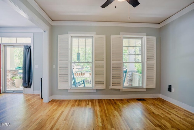 doorway with light wood-type flooring, ceiling fan, baseboards, and crown molding