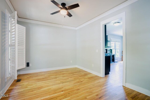 unfurnished room featuring ceiling fan, light wood-type flooring, crown molding, and baseboards