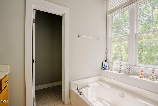 full bath featuring tile patterned floors, plenty of natural light, a bath, and vanity