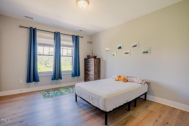 bedroom with baseboards and light wood finished floors