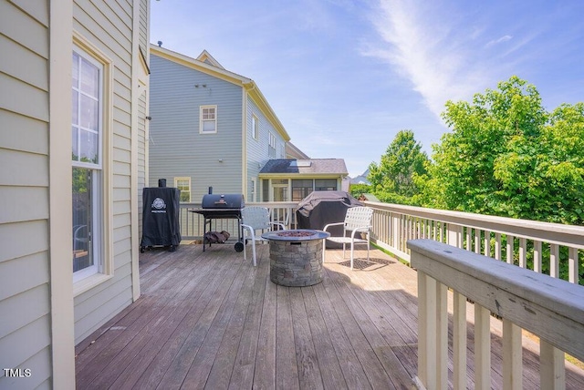 deck with a fire pit and a grill