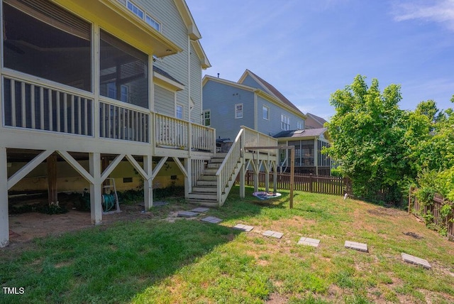 view of yard with a sunroom, a deck, and stairway