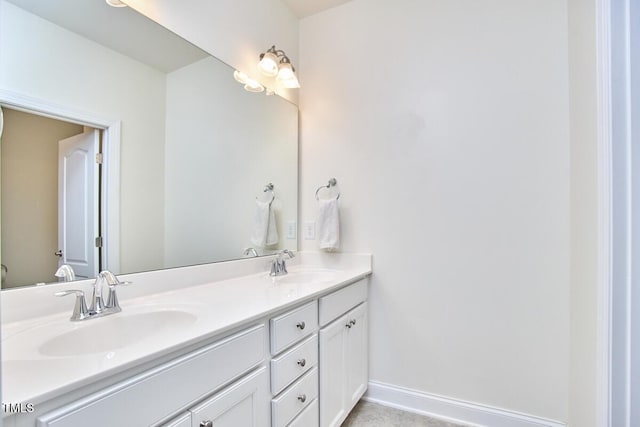 bathroom with double vanity and baseboards