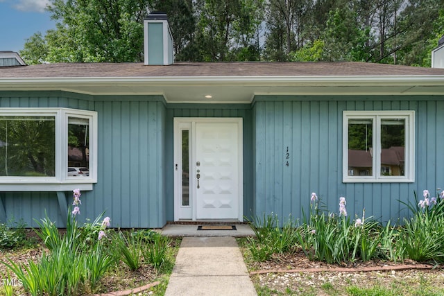 property entrance featuring a shingled roof