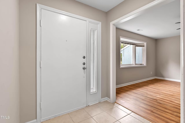 entryway featuring baseboards and light tile patterned flooring