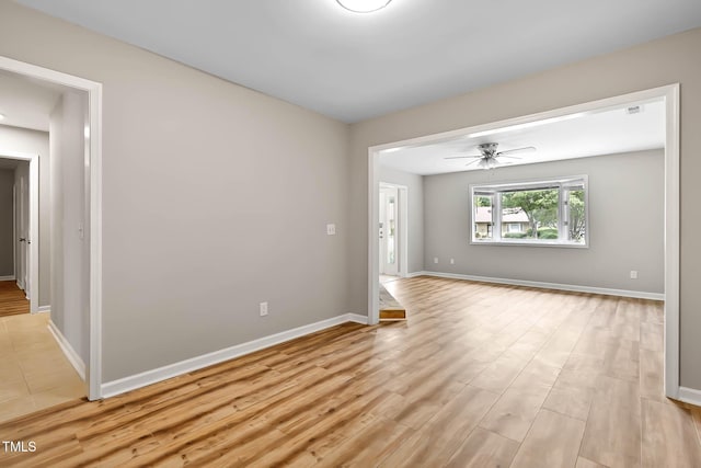 unfurnished room with light wood-style floors, baseboards, and a ceiling fan