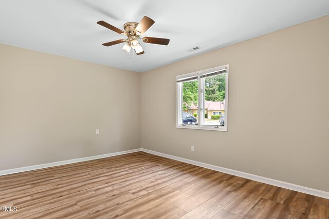 empty room featuring baseboards, light wood-style flooring, and ceiling fan